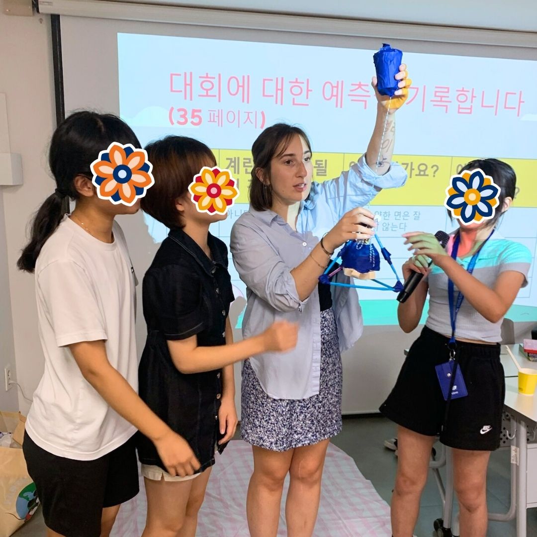GEM Program volunteer and students presenting in front of a classroom screen during a group session.