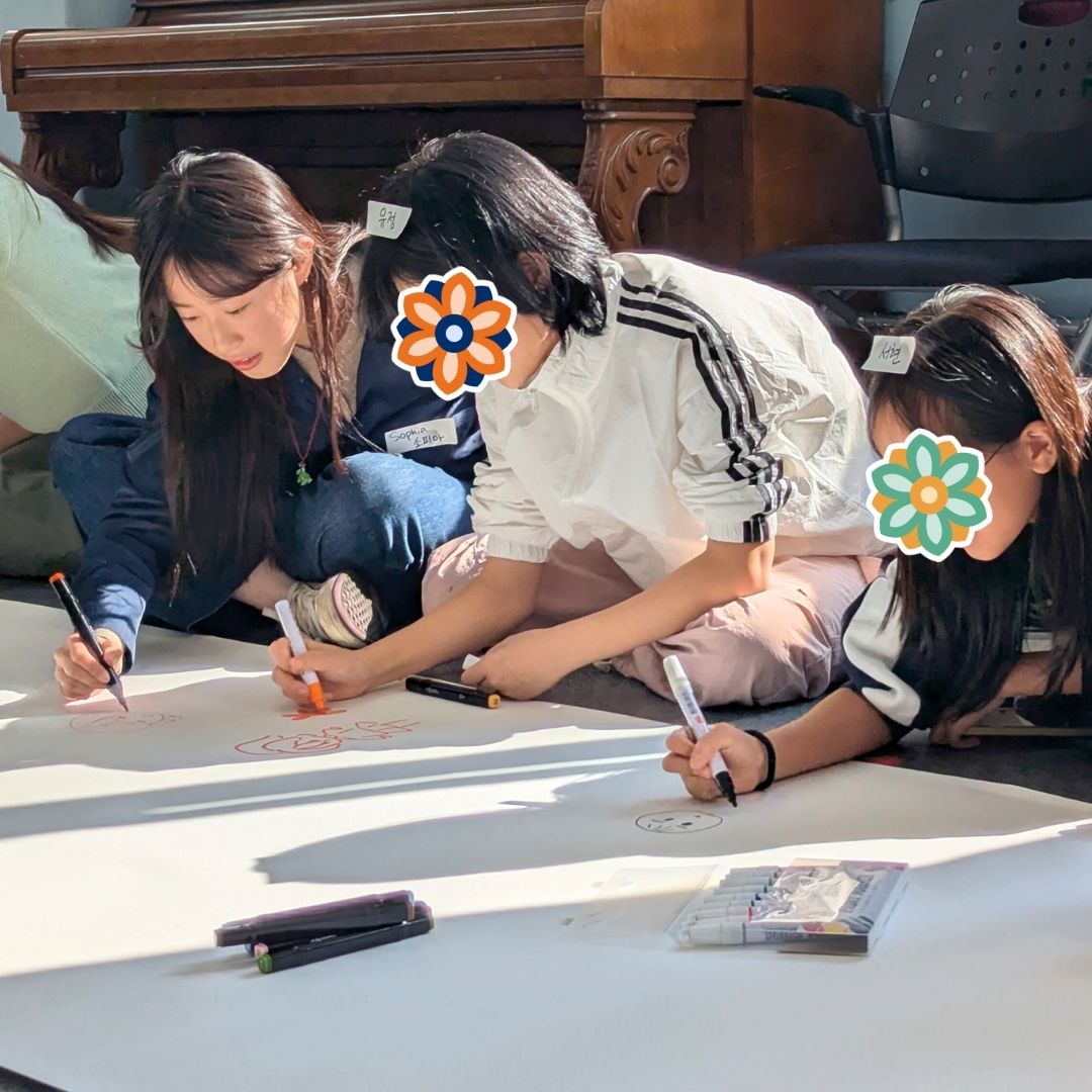 GEM Program students and volunteerss writing and drawing together during a collaborative activity.