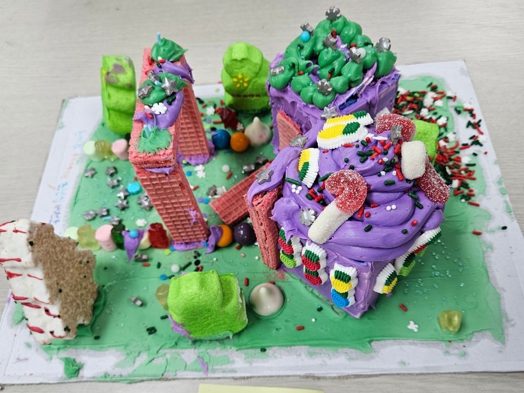 Colorful gingerbread house decorated by children during a KKOOM holiday activity.