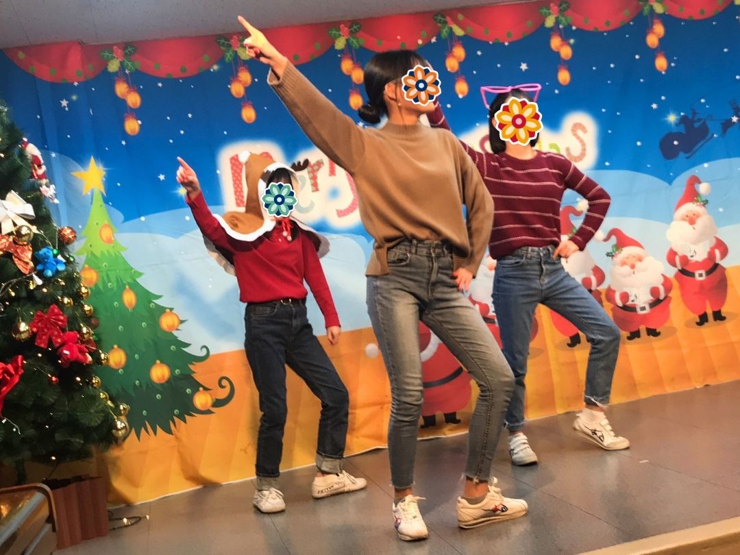 Children dancing on stage during a KKOOM holiday party.