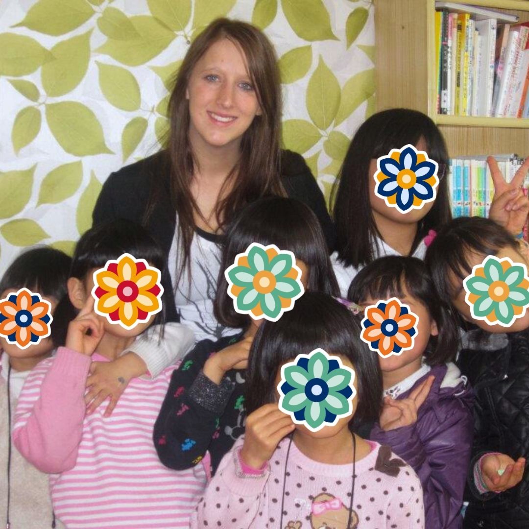 Volunteer and children gathered closely during a warm family-style moment at a KKOOM-supported home.