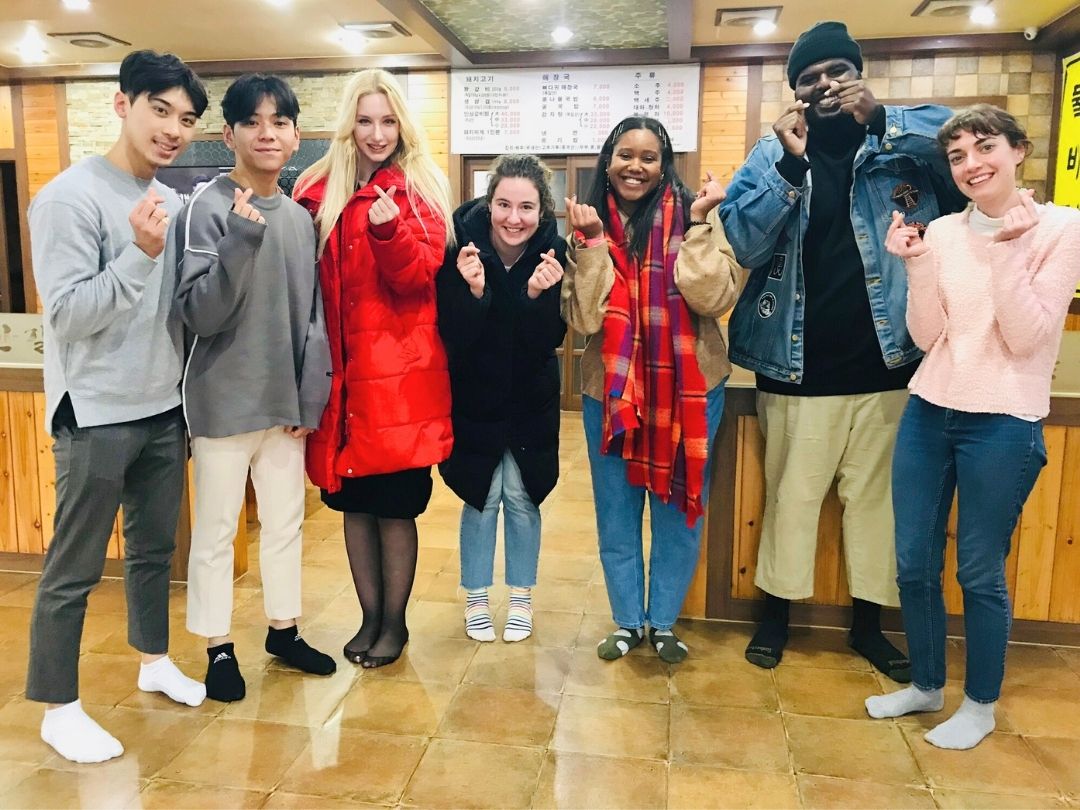 KKOOM volunteers posing together at a restaurant during a visit to a children’s home.