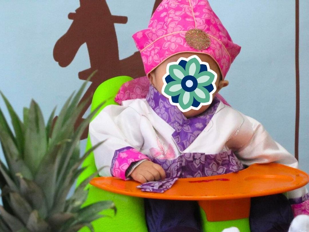 Baby wearing a pink traditional Korean hanbok as part of KKOOM’s Welcome Boost support program.