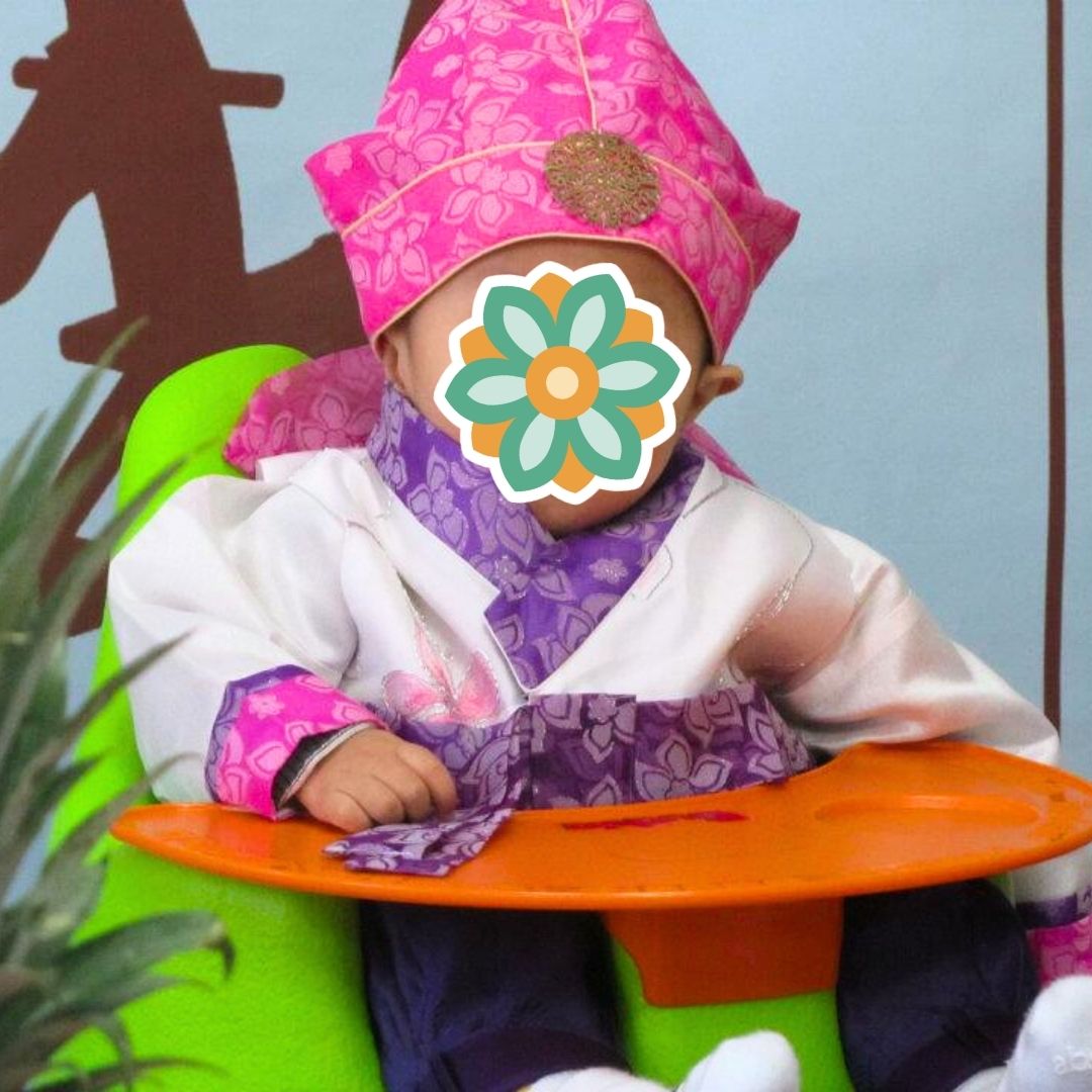 Baby wearing a pink traditional Korean hanbok as part of KKOOM’s Welcome Boost support program.